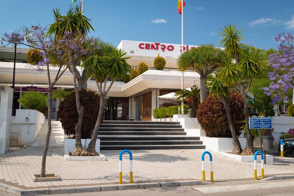 A modern building with a white facade and a red sign reading "CENTRO".