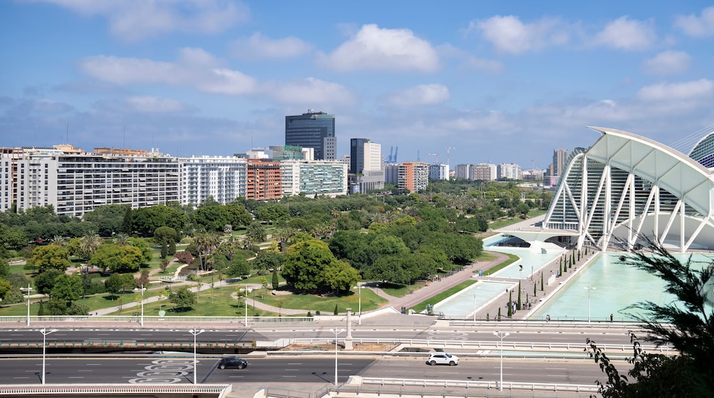 Un paisaje urbano con edificios modernos, un puente grande y un parque con árboles.