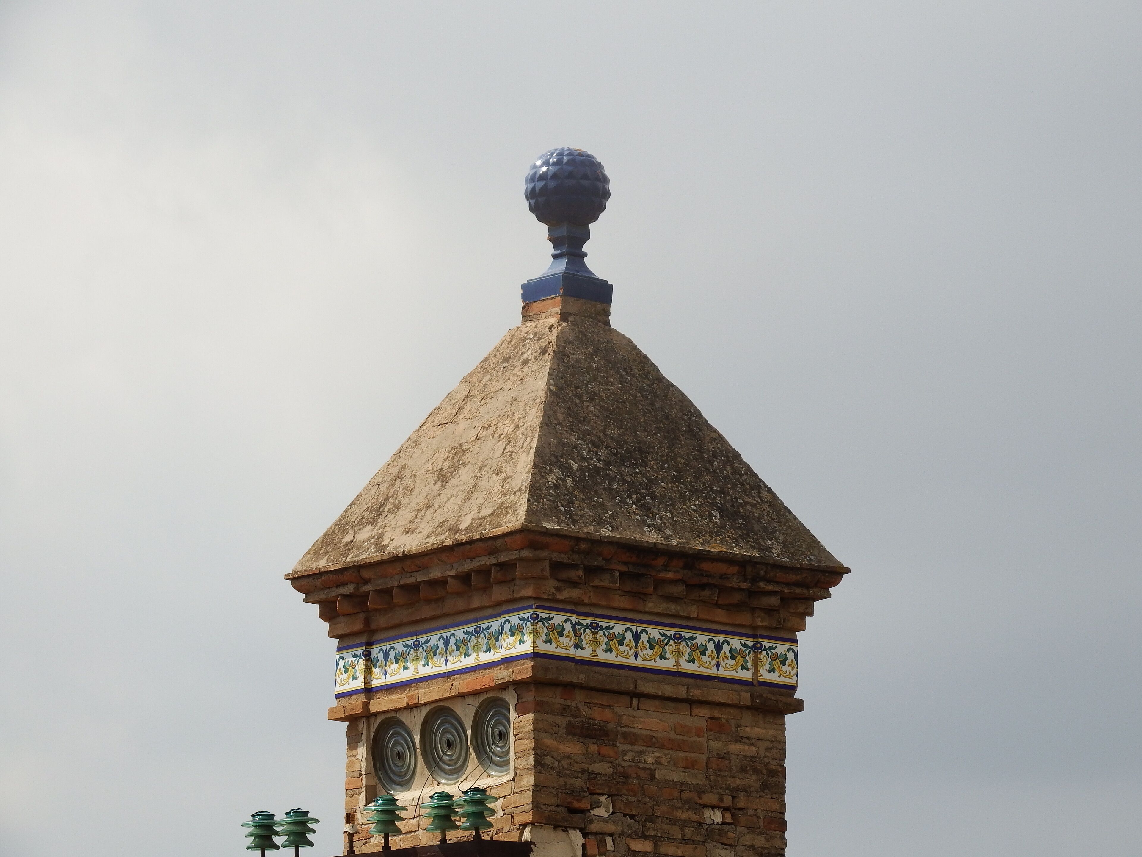 A tower with a pointed roof and a decorative finial.