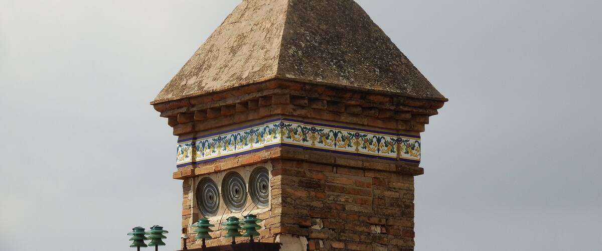 A tower with a pointed roof and a decorative finial.