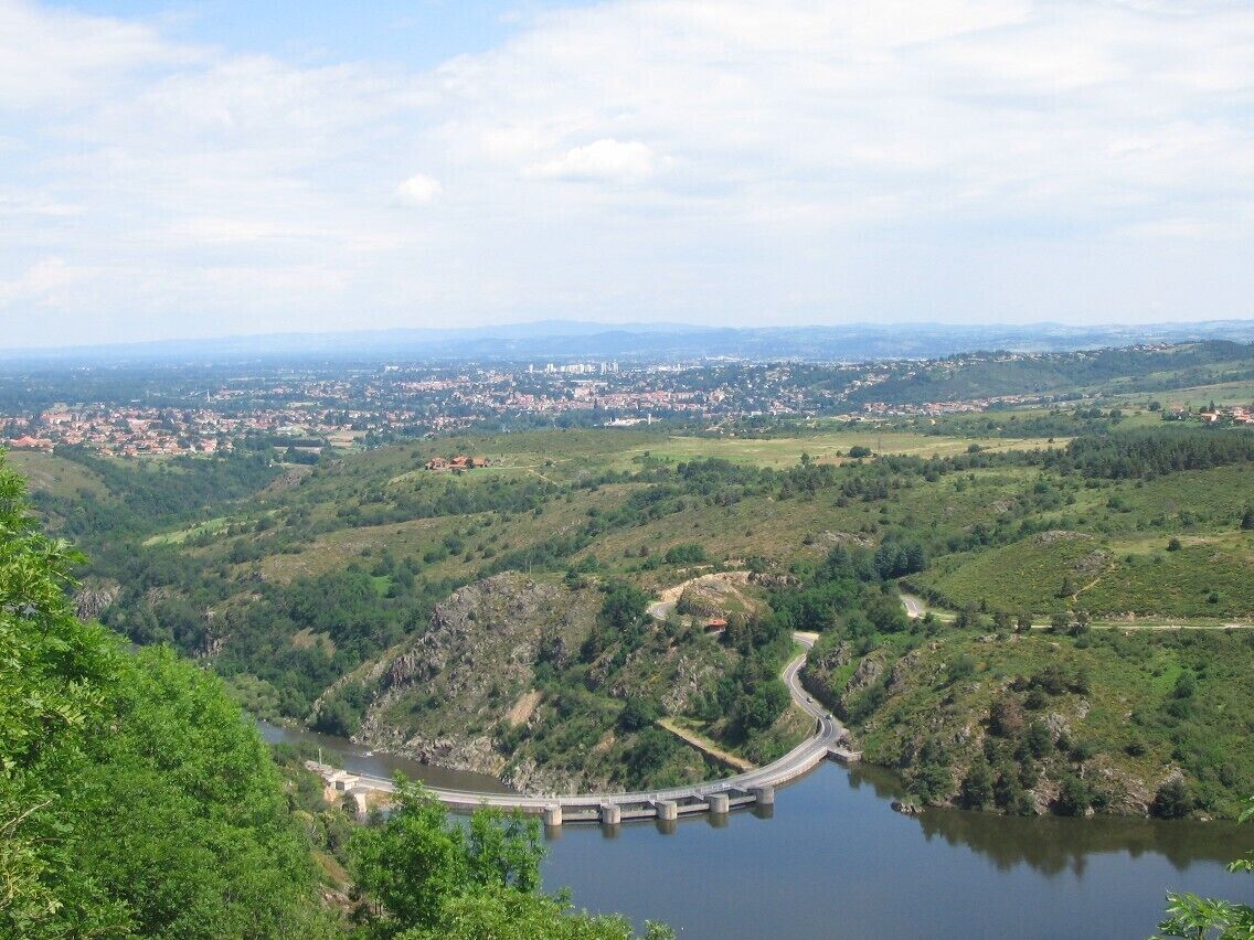 A dam with a bridge, a river, and a town in the valley.