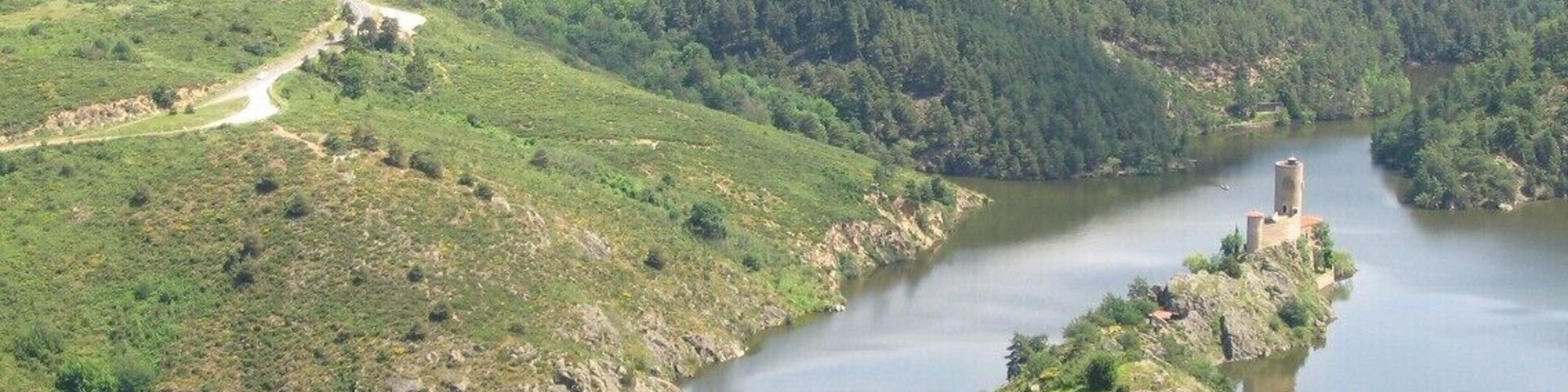 Les vestiges des chùteau et chapelle de Grangent, datés IXe s., ne se sont pas toujours trouvés sur une ßle. Ils furent bùtis à l'origine au sommet d'un promontoire rocheux dominant le cours du fleuve d'une soixantaine de mÚtres... ce n'est que lors de la mise en eau du barrage en 1957, que le domaine s'est trouvé séparé de son grand frÚre d'Essalois, sur le plateau de Chambles.
