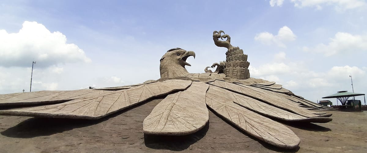 Une grande sculpture de sable représentant un oiseau aux ailes déployées et au bec ouvert.