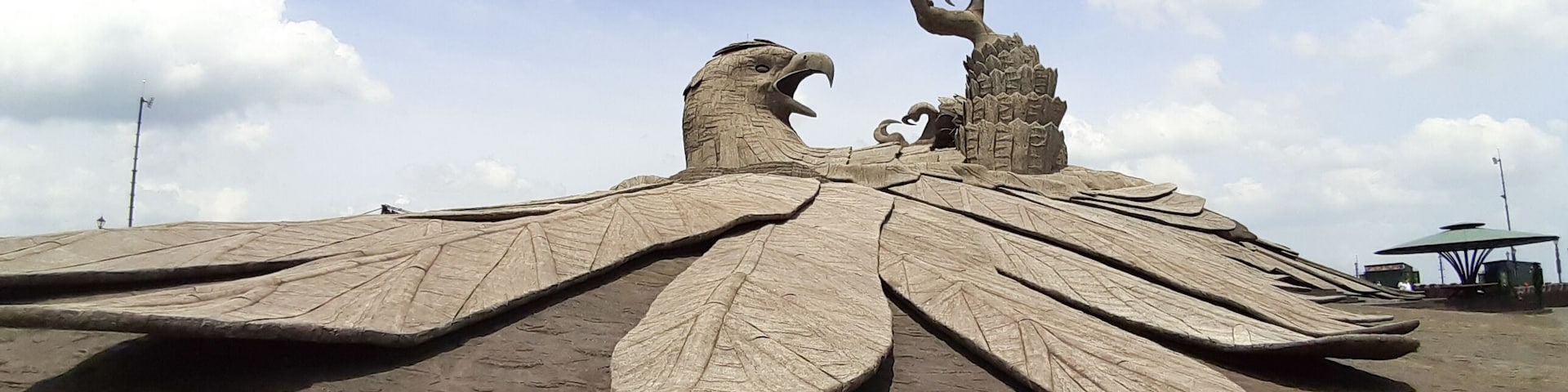Grande escultura de areia representando um pássaro com asas abertas e bico.