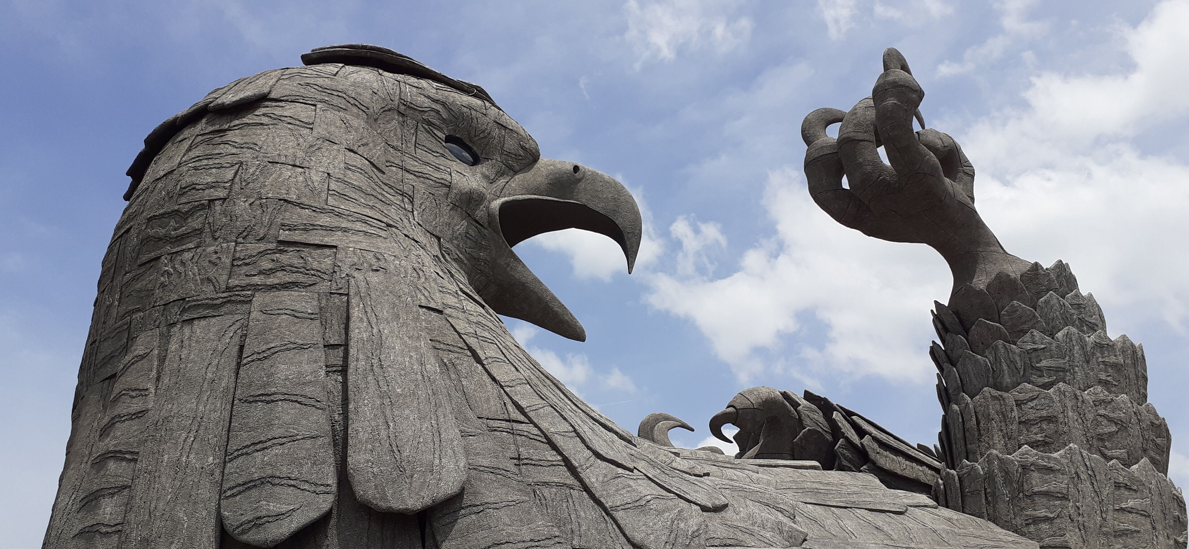 A large stone eagle sculpture with outstretched talons.