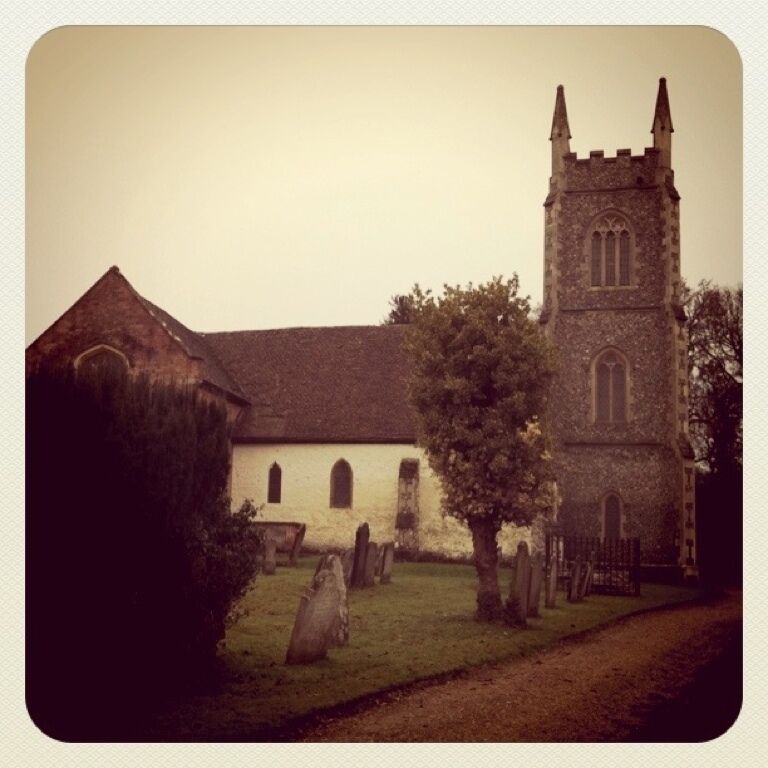 A church with a tall tower and a graveyard.