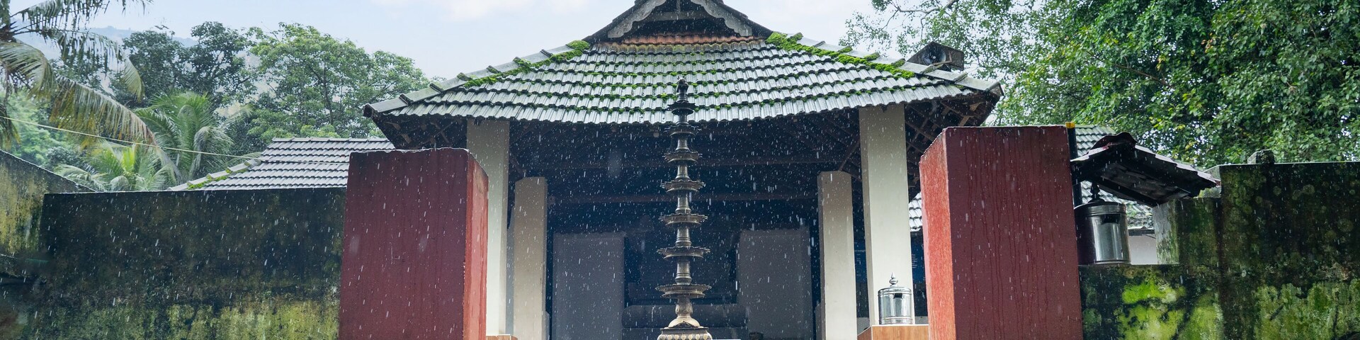 Una pagoda japonesa tradicional con tejado de tejas, rodeada de exuberante follaje y una escalera de piedra que conduce a ella.