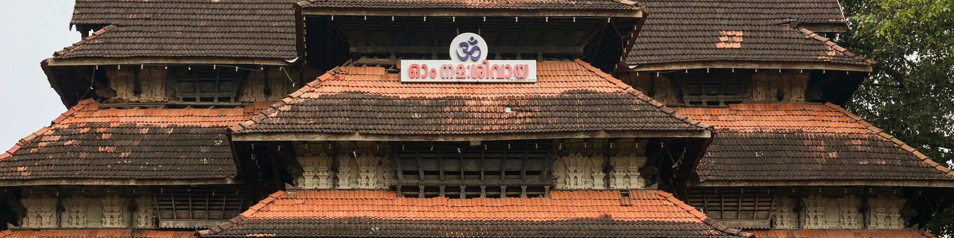 Um templo tradicional com vários níveis, esculturas elaboradas e telhado de telhas vermelhas.
