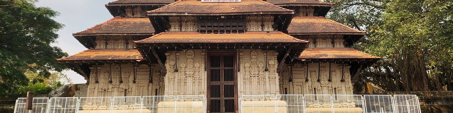Vadakkumnathan or lord shiva ancient old traditional style south indian hindu religion stone temple building in kerala, thrissur. Front view with Om Namah Shivaya Mantra text in Malayalam language.