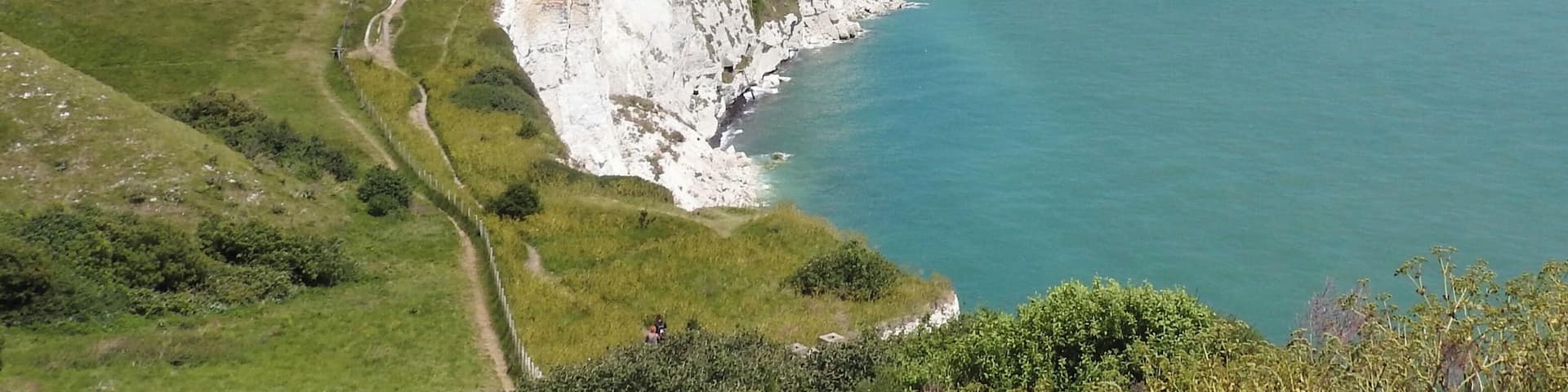 Dover, England, is a major port for ferries to Calais, France. The White Cliffs of Dover form part of the English coastline facing the Strait of Dover and France. The cliff face, which reaches a height of 350 feet (110Â m), owes its striking appearance to its composition of chalk accented by streaks of black flint. The cliffs, on both sides of the town of Dover in Kent, stretch for eight miles (13Â km). June 2017