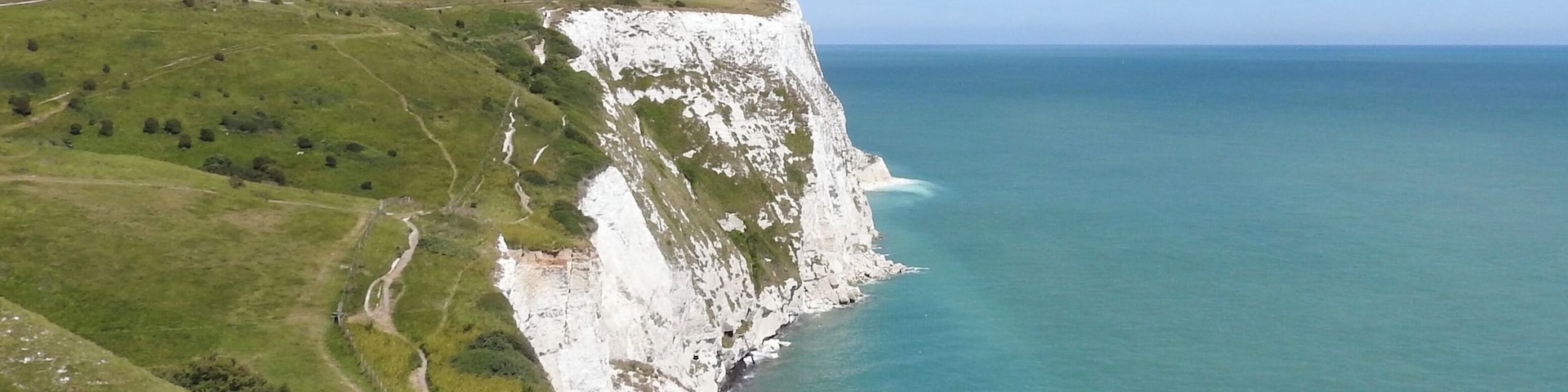 Dover, England, is a major port for ferries to Calais, France. The White Cliffs of Dover form part of the English coastline facing the Strait of Dover and France. The cliff face, which reaches a height of 350 feet (110 m), owes its striking appearance to its composition of chalk accented by streaks of black flint. The cliffs, on both sides of the town of Dover in Kent, stretch for eight miles (13 km). June 2017
