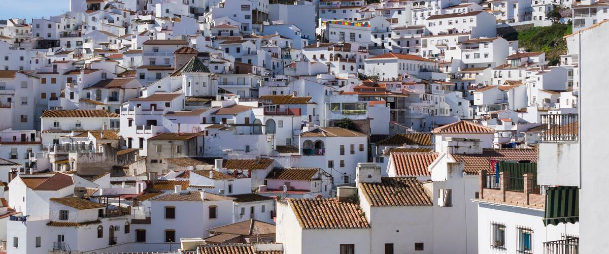 A densely packed hillside of white buildings with terracotta roofs.
