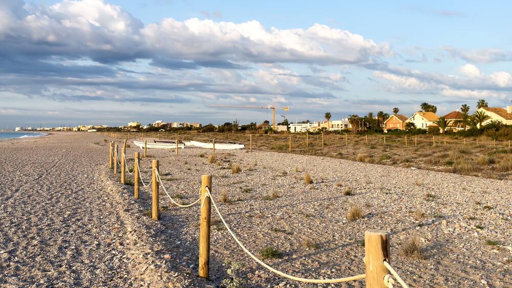 Pebble stone beach. Sea beach ocean shore. Coastline on empty pebble beach. Sea beach landscape. Coast pebbles. Shore landscape on Spain resort, Almarda. House on coastline. Waterfront vacation home