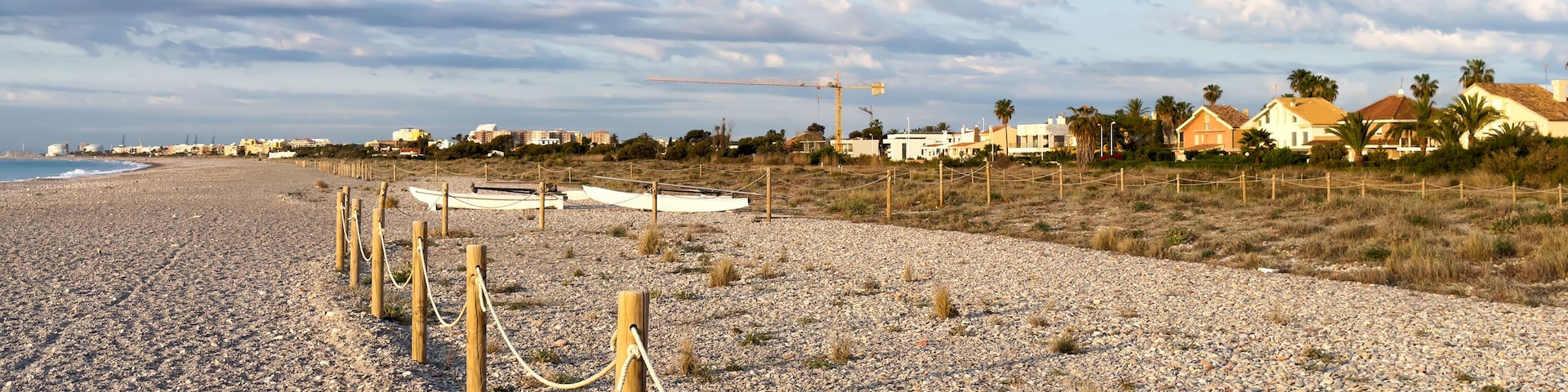 Pebble stone beach. Sea beach ocean shore. Coastline on empty pebble beach. Sea beach landscape. Coast pebbles. Shore landscape on Spain resort, Almarda. House on coastline. Waterfront vacation home