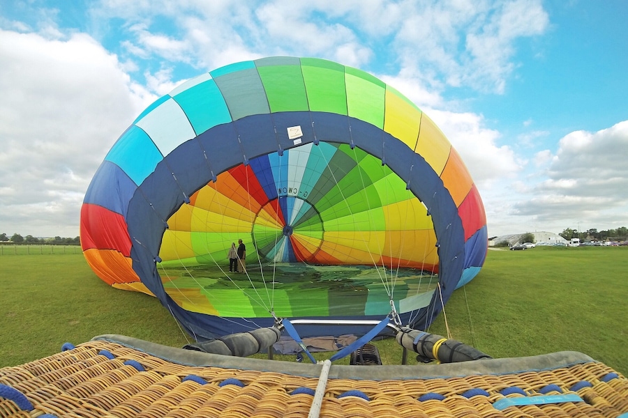 Un globo aerostático colorido en un campo con cielo despejado.
