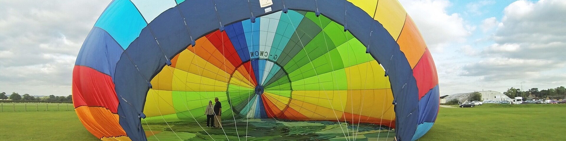 Un globo aerostático colorido en un campo con cielo despejado.