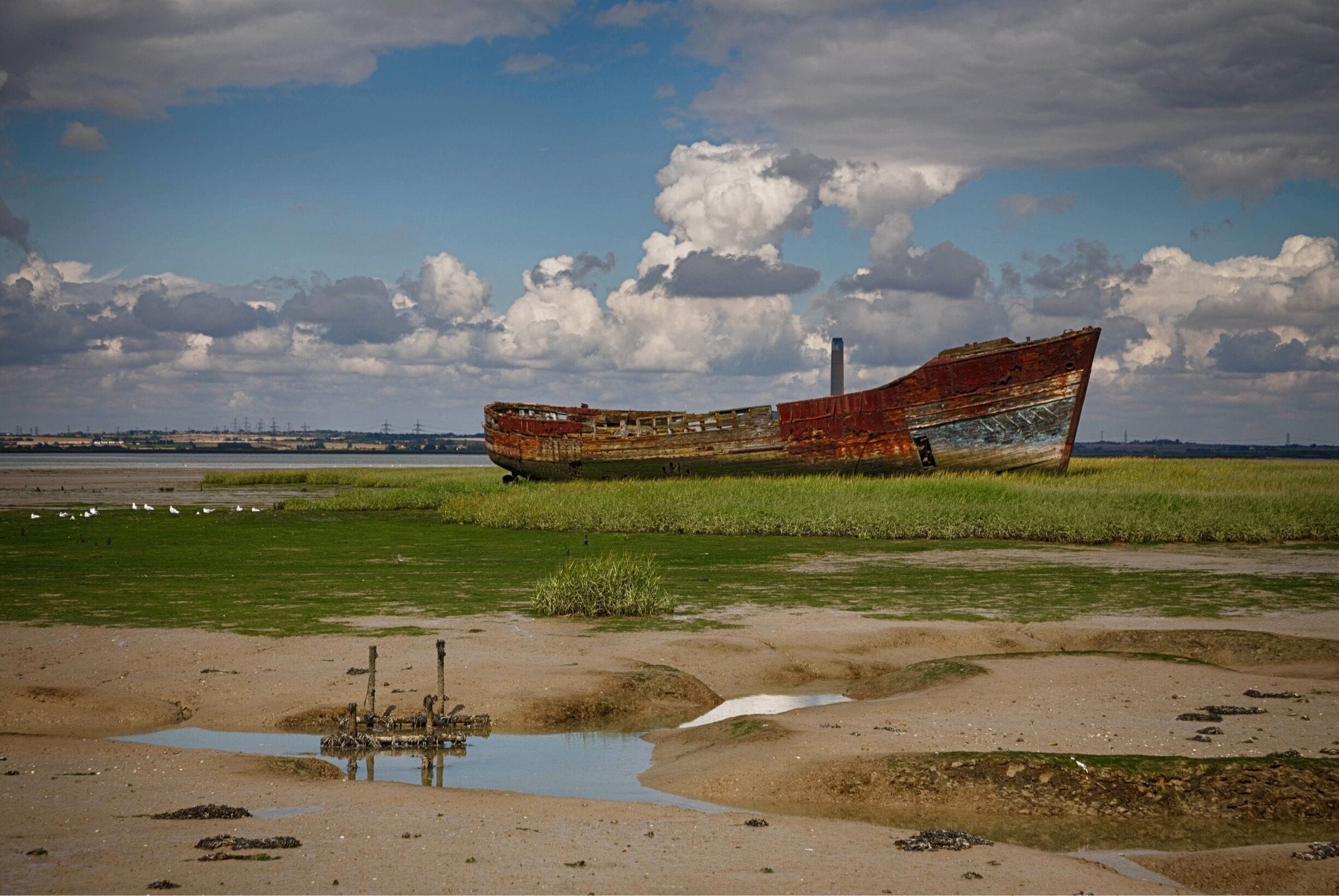 Wreck of an old boat, sitting just off the river side at Motney Hill, North Kent.

Part of the Riverside Country Park, this coastal walk takes in a varied amount of wildlife, from many species of birds who dwell in the salt marshes and mudflats to the seals often seen sitting on the little islands dotted around the estuary.