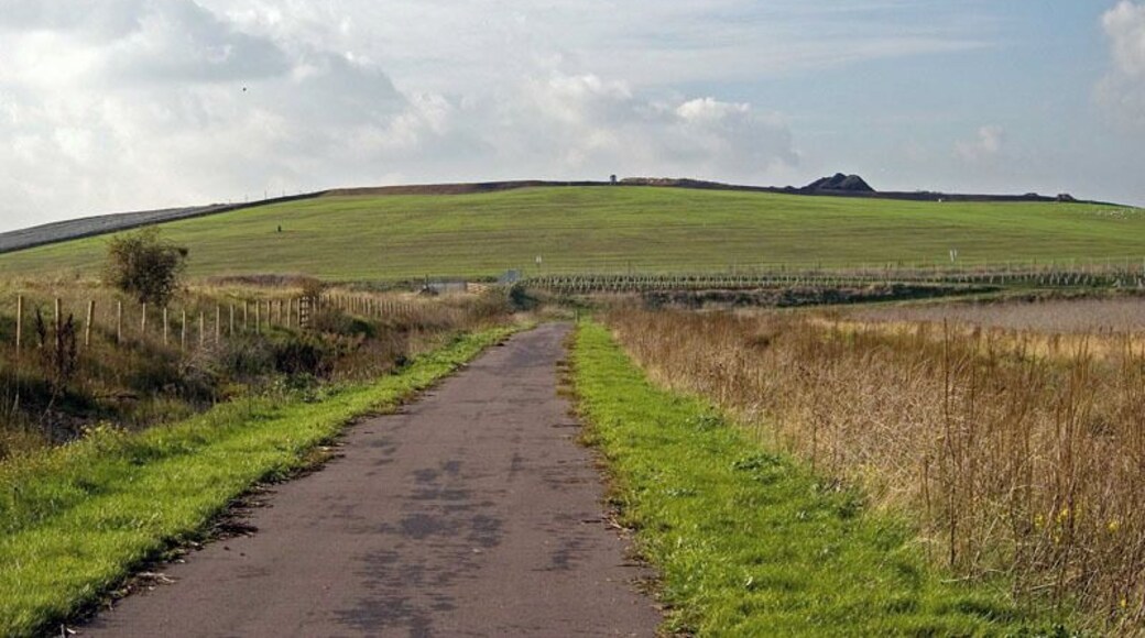 National Cycle Route 13 This is National Cycle Route 13 as it passes through Aveley / Rainham Marshes. Until earlier this year this square was inaccessible to the general public as it was partly on the Purfleet Ranges and the landfill site that is the hill in the back ground of the photo. Cycle Route 13 when finished will be able to take you to Fakenham in Norfolk or heading in the direction of the photo Hackney.