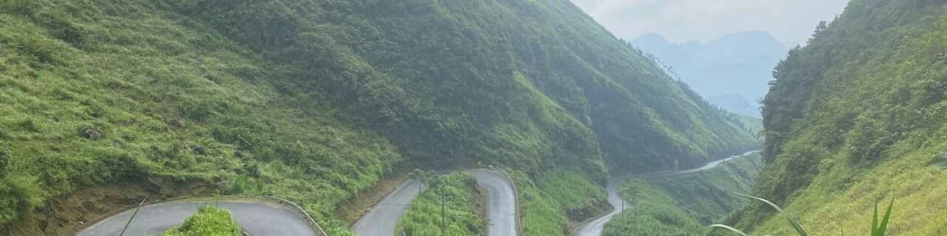 Una carretera sinuosa en la montaña, rodeada de vegetación exuberante.