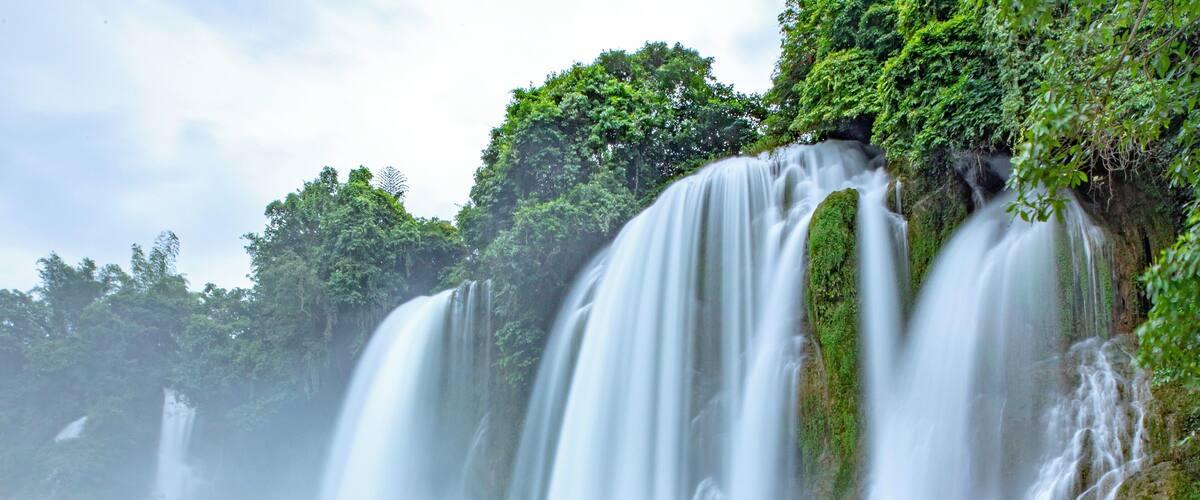 A waterfall cascading over rocks in a lush, green forest.