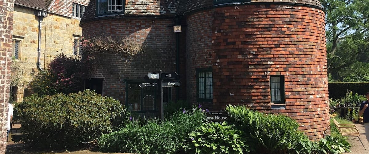 A historic brick building with a conical tower and a traditional window design.