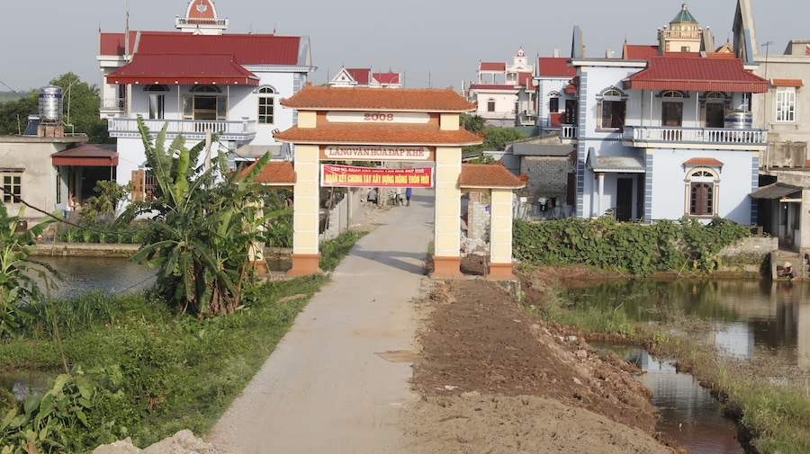 A pathway leading to a building with a sign reading "LANG VANHOADAP KHE".