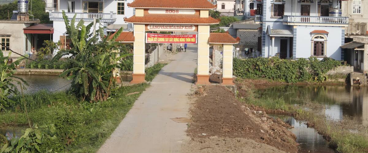 A pathway leading to a building with a sign reading "LANG VANHOADAP KHE".