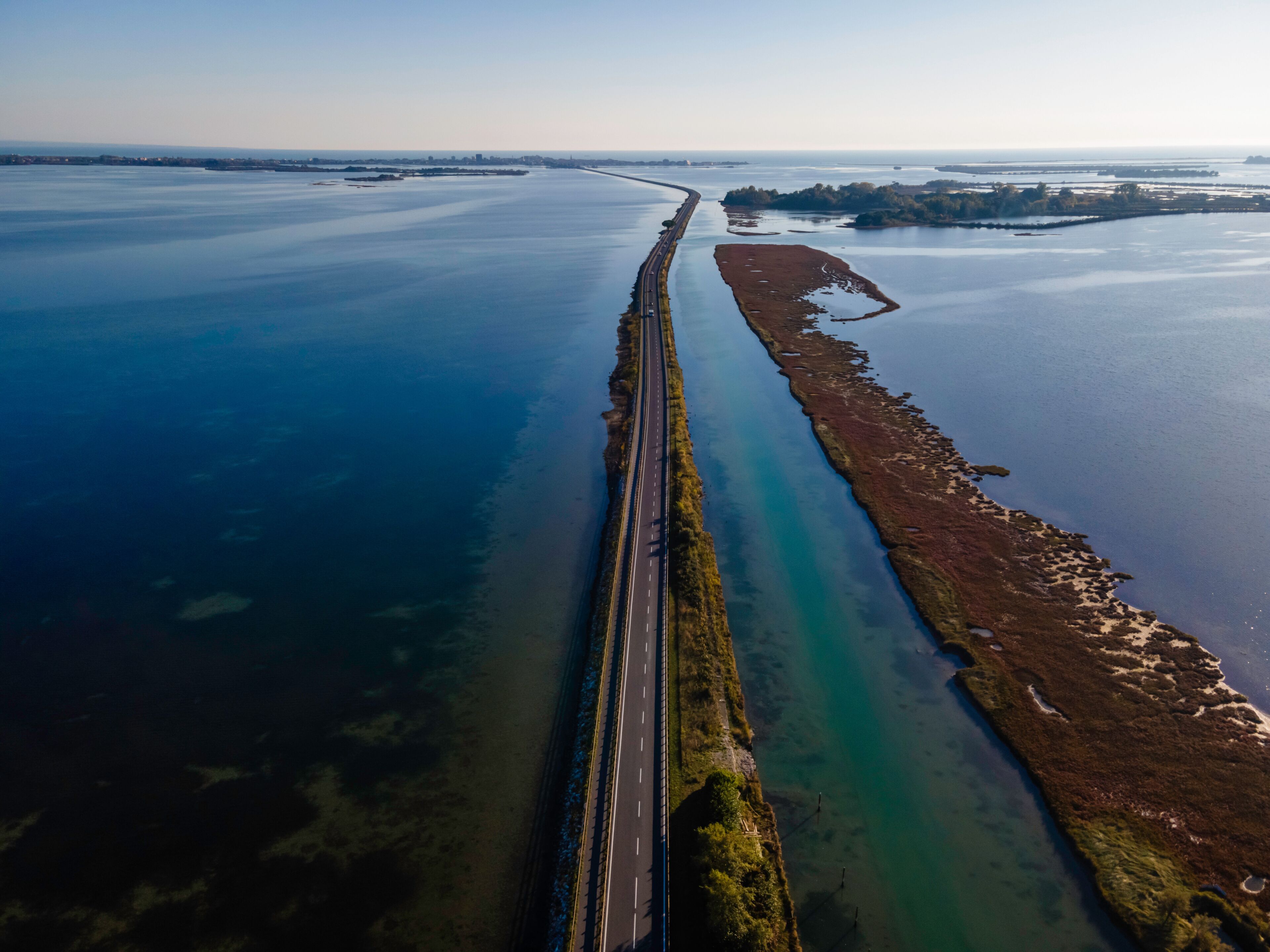 Aerial view of vehicles driving on a beautiful road crossing the lagoon in Grado near Gorizia, Friuli Venezia Giulia, Italy.