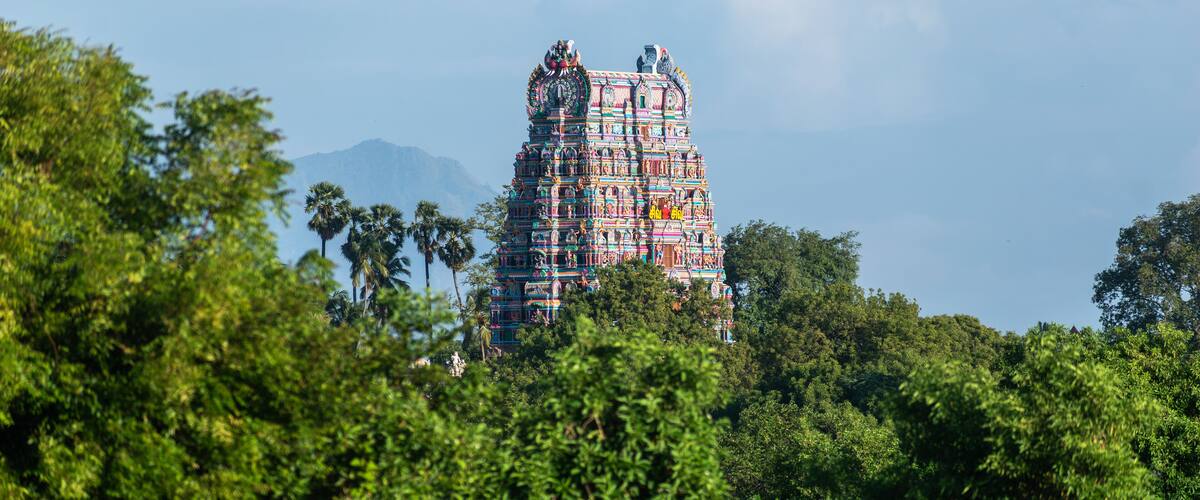 A colorful temple surrounded by lush greenery.