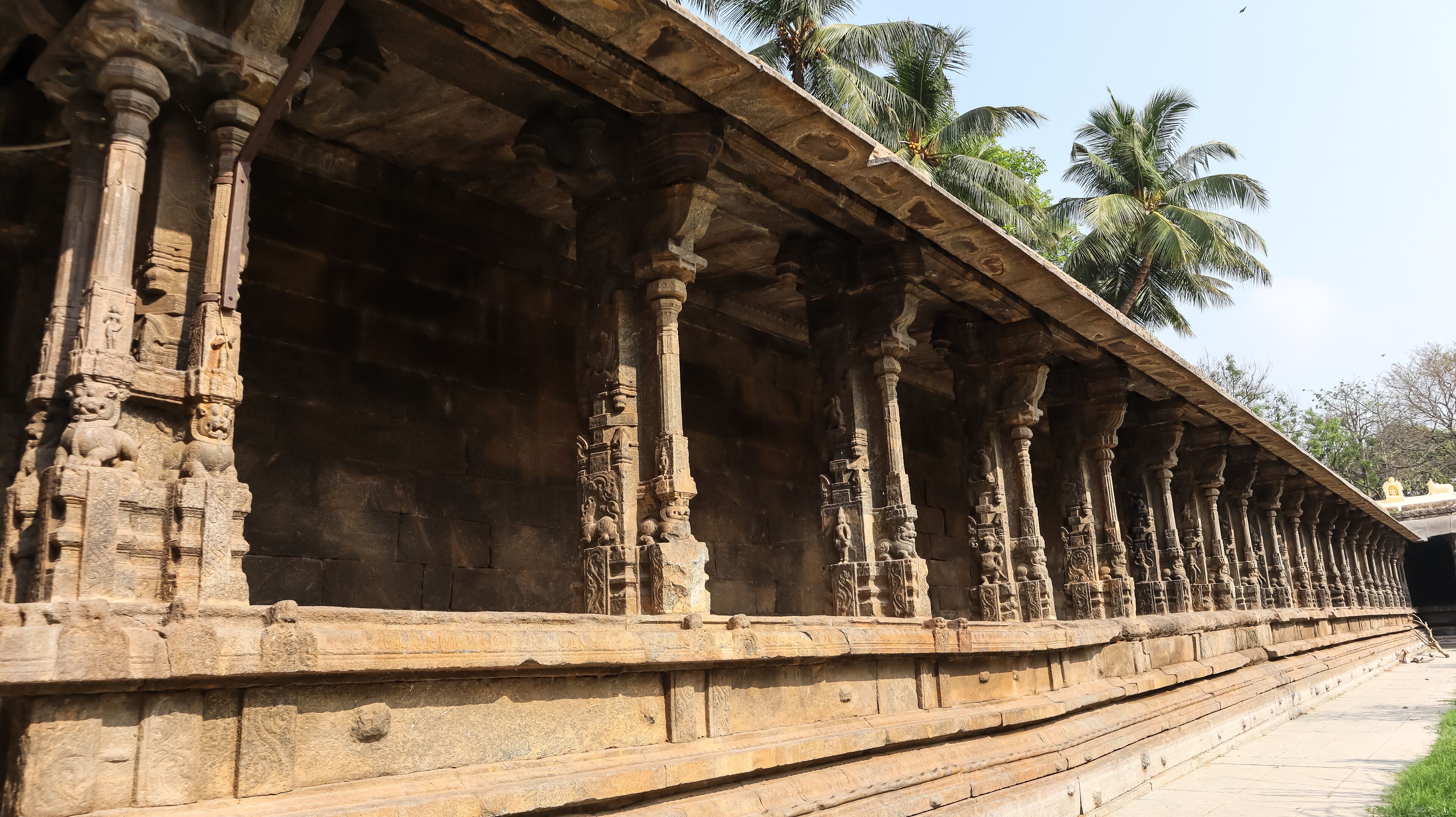 A stone corridor with intricate carvings and columns.