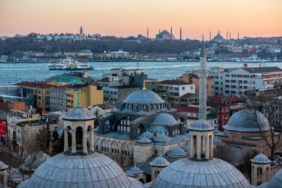 A cityscape with domed buildings and a river.