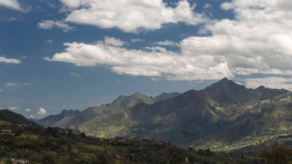 A mountainous landscape with a village nestled in the valley.