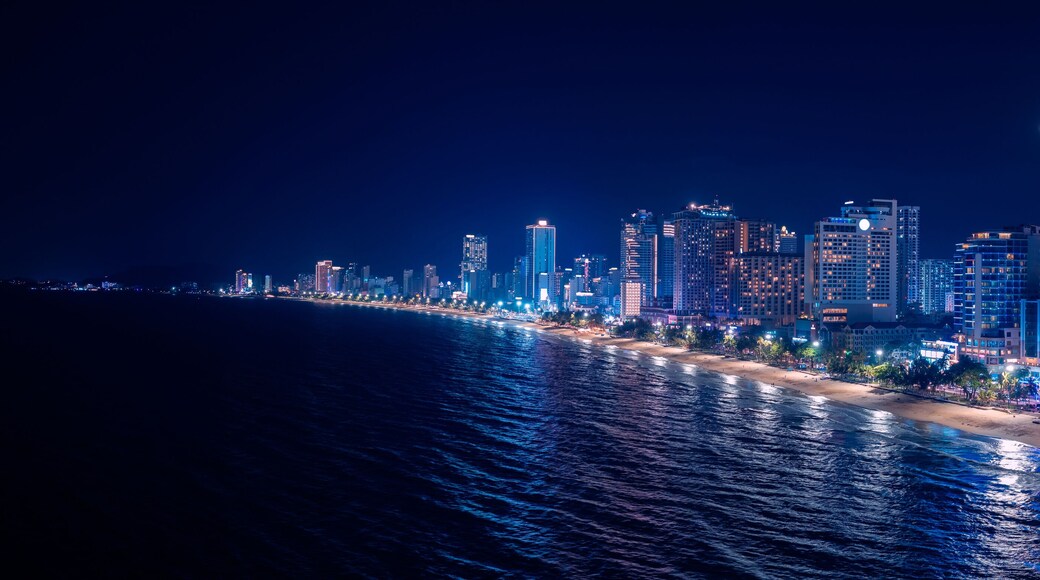 Scenic night aerial view of Nha Trang city with skyscraper neon light and bay of South China Sea in Khanh Hoa province, Vietnam.