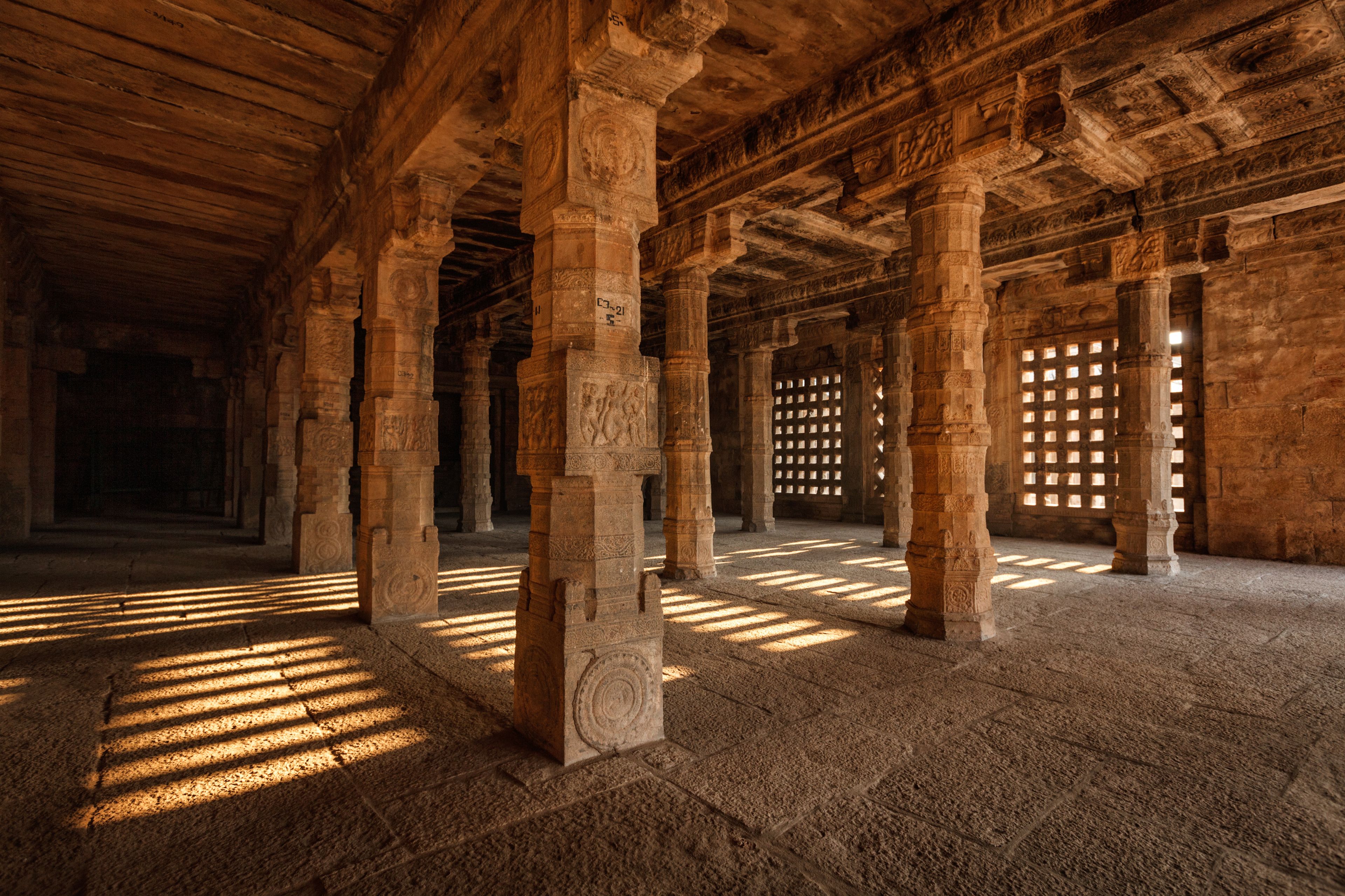An ancient stone structure with columns and intricate carvings.