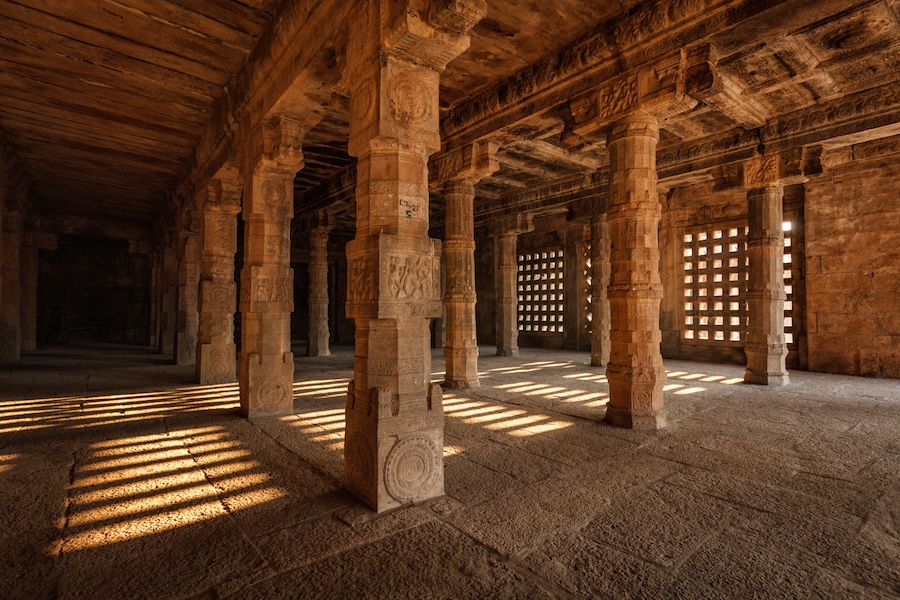 An ancient stone structure with columns and intricate carvings.
