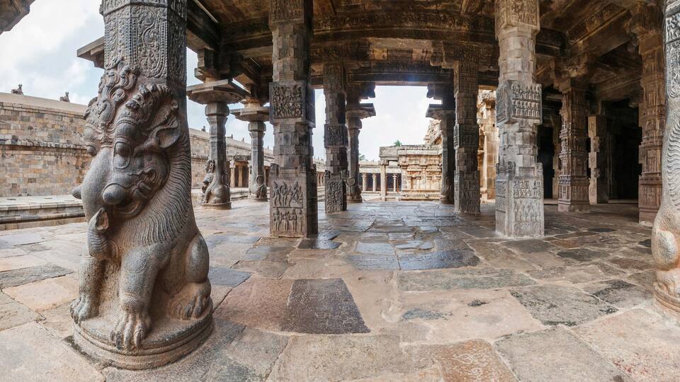 An ancient stone structure with intricate carvings and lion statues.