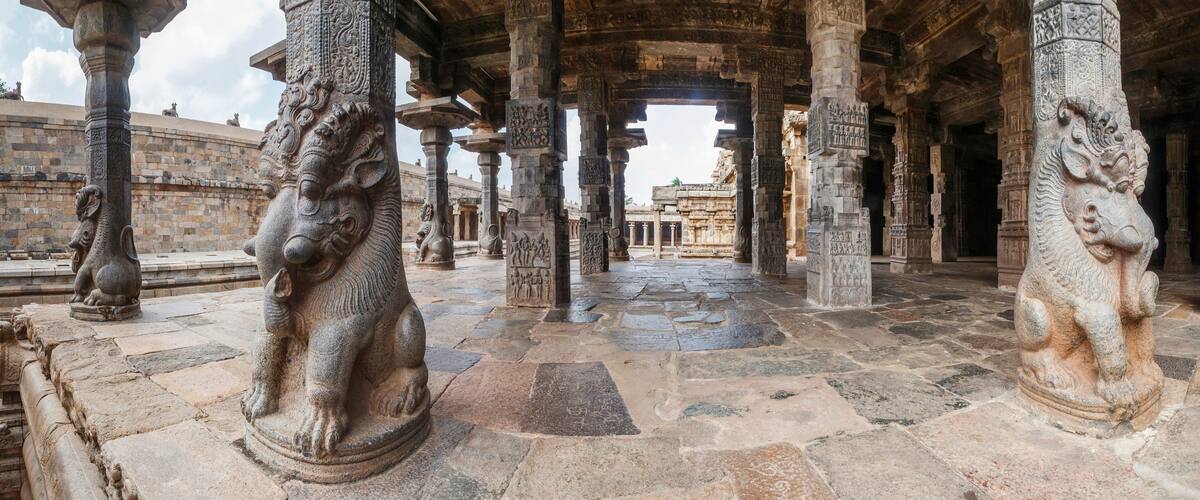 An ancient stone structure with intricate carvings and lion statues.