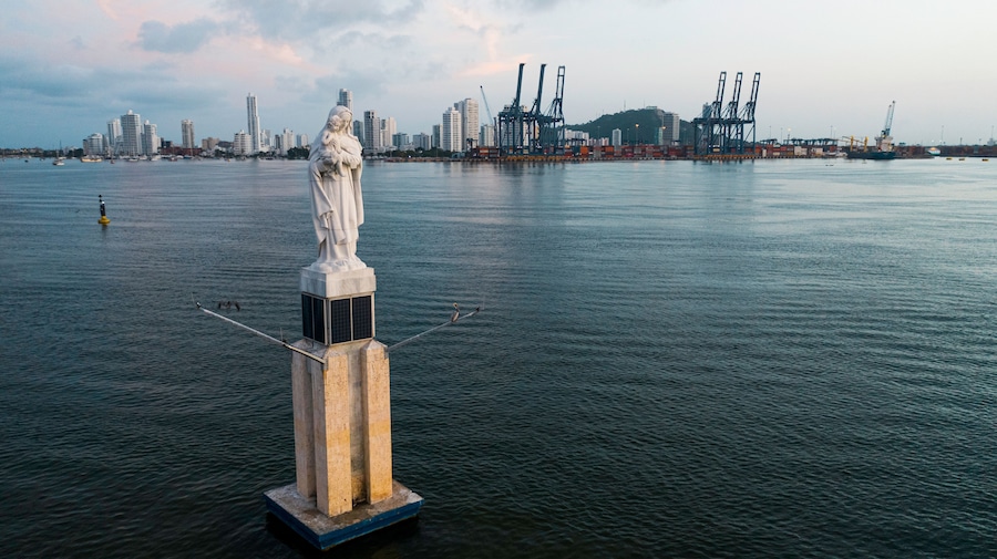 Una estatua en el agua, con el perfil de la ciudad al fondo.