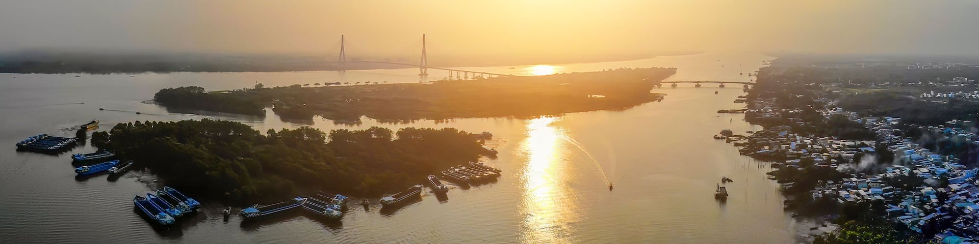 aerial sunset view of Can Tho bridge, Can Tho City with development buildings, transportation, energy power infrastructure.