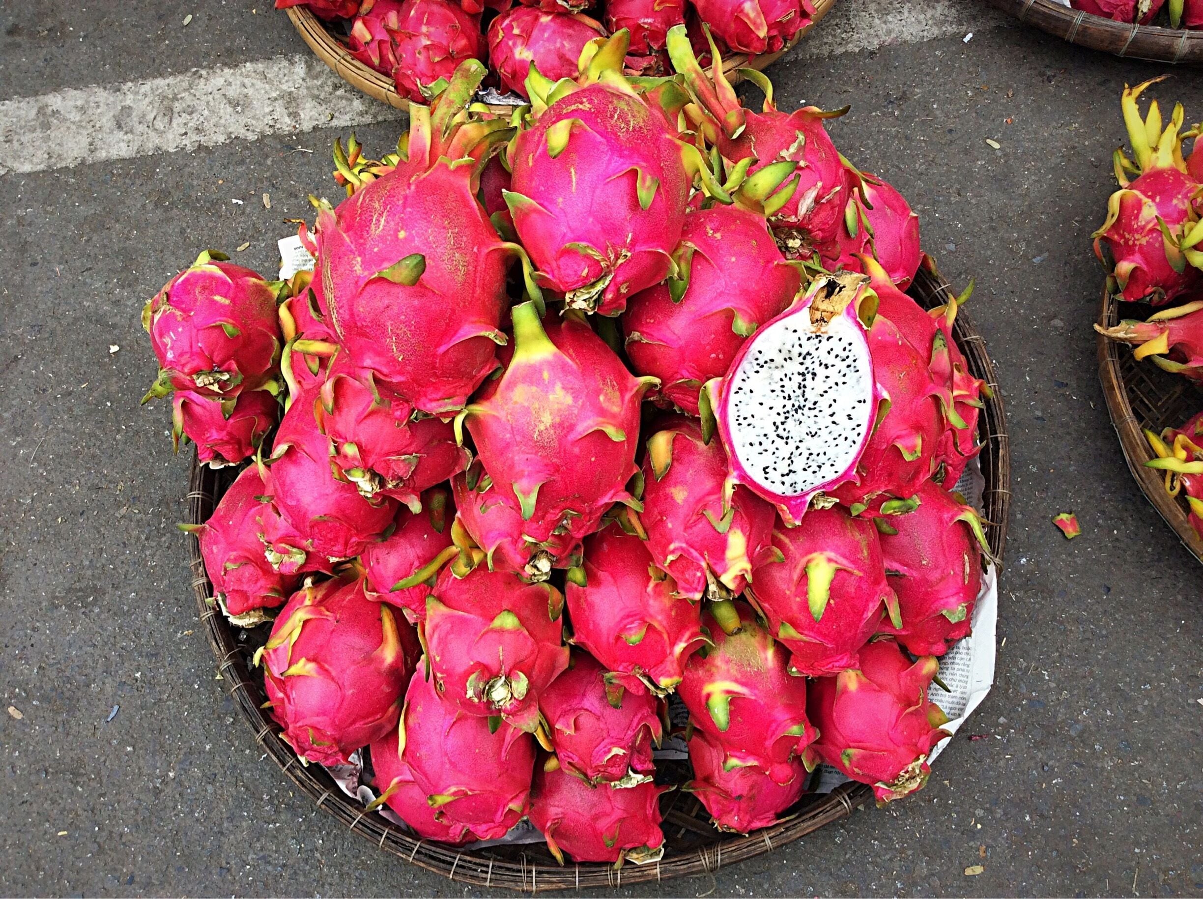 These fruits are called Dragon Fruit. I understand it is easily available in markets in Vietnam.
