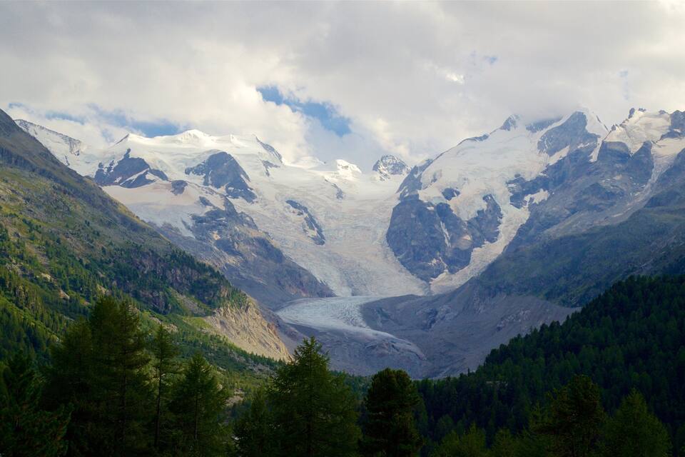Un paisatge de vall glacial amb muntanyes nevades i boscos densos.