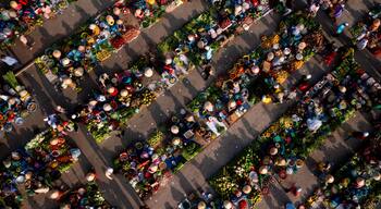 An aerial view of a bustling market with rows of vendors selling fruits, vegetables, and other goods.