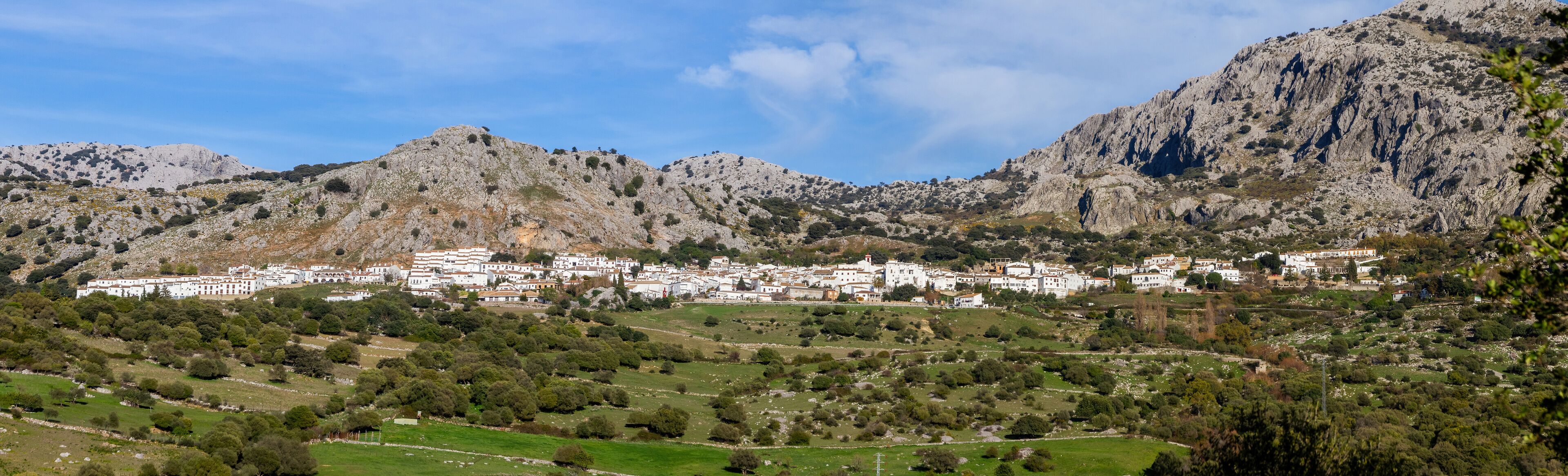 A town nestled in a valley with rugged mountains in the background.