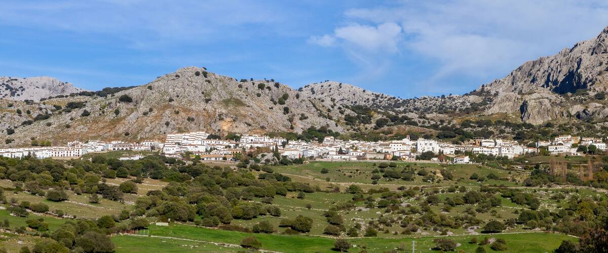 A town nestled in a valley with rugged mountains in the background.