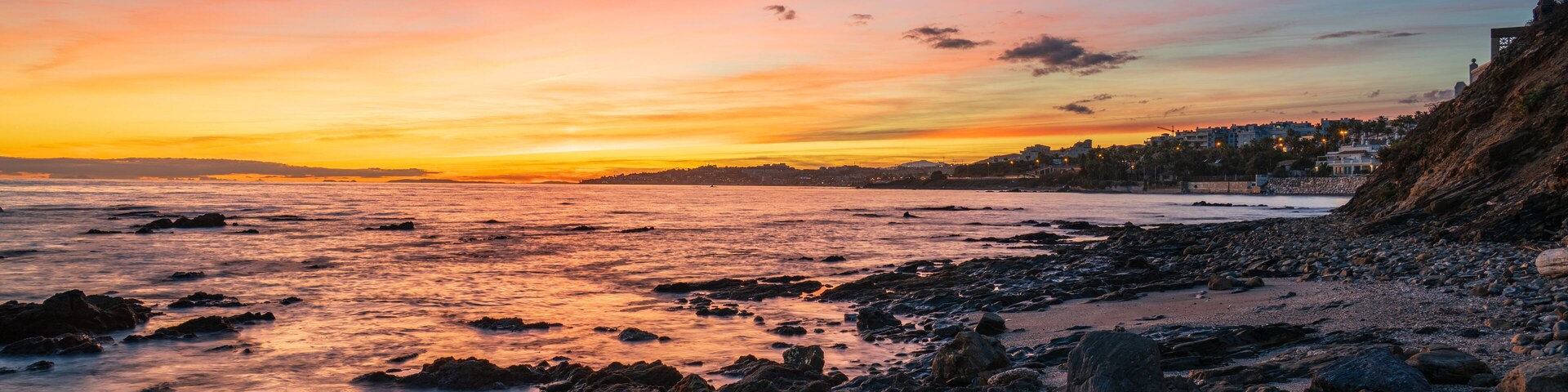 Una costa rocosa al atardecer con cielo despejado.