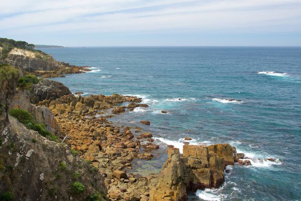 A rocky coastline with waves crashing against the shore.
