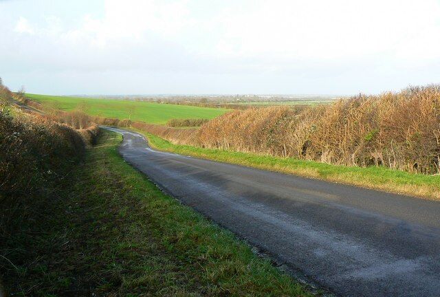 The road from Hannington to Castle Eaton, Wiltshire This road is heading north-west. The area on the skyline is in the neighbouring county of Gloucestershire.