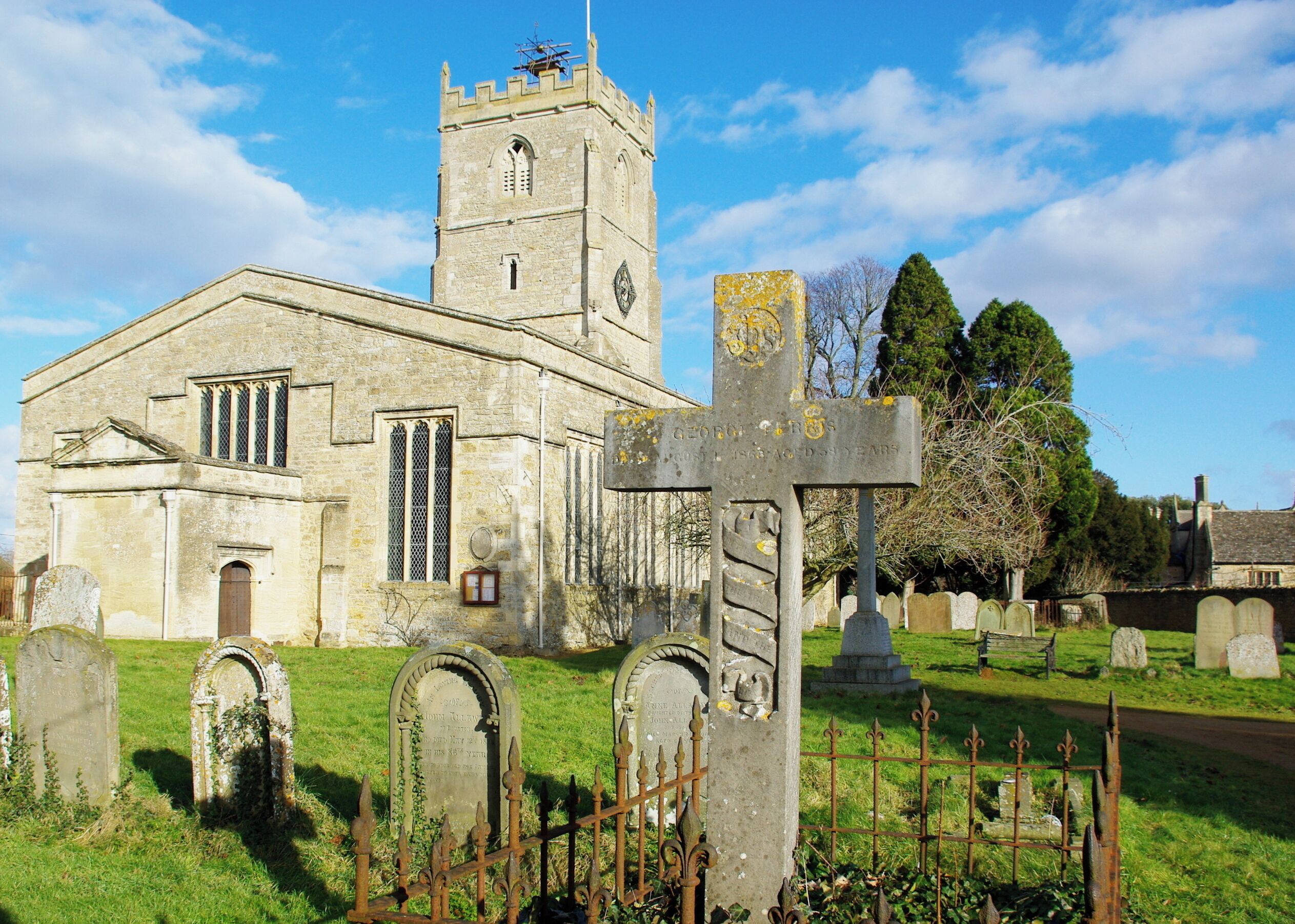 A church with a tall tower and a large cross in the foreground.