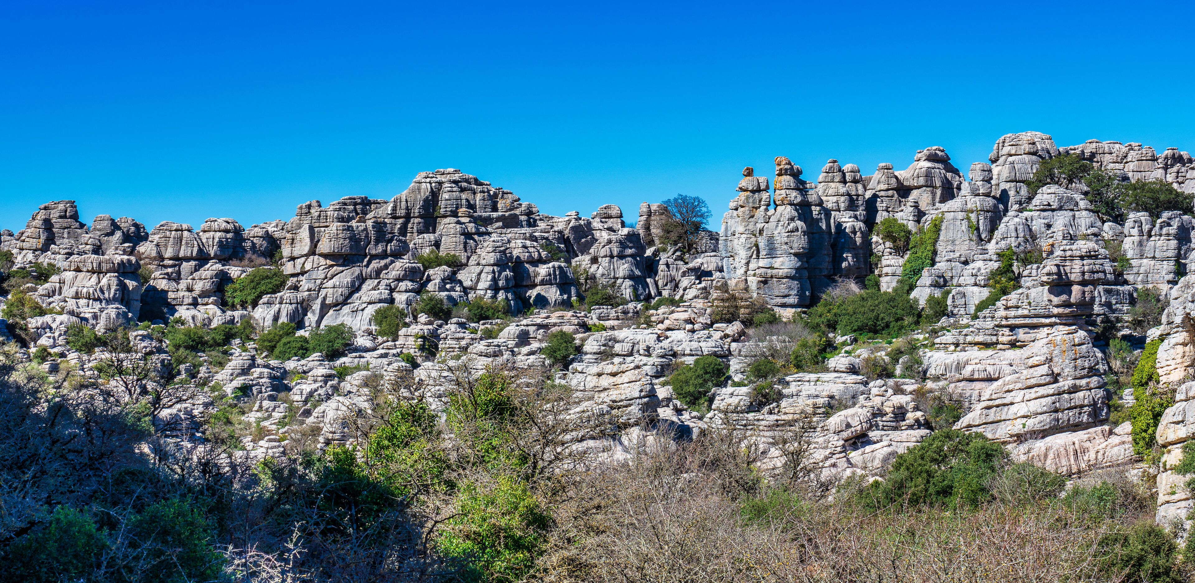 A rugged landscape with layered rock formations and sparse vegetation.