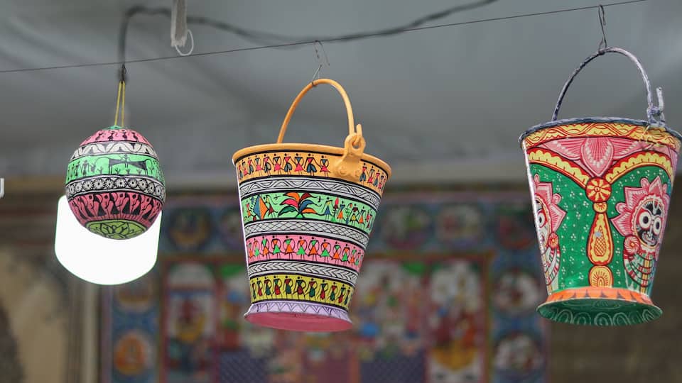 Three colorful hanging containers with intricate patterns.